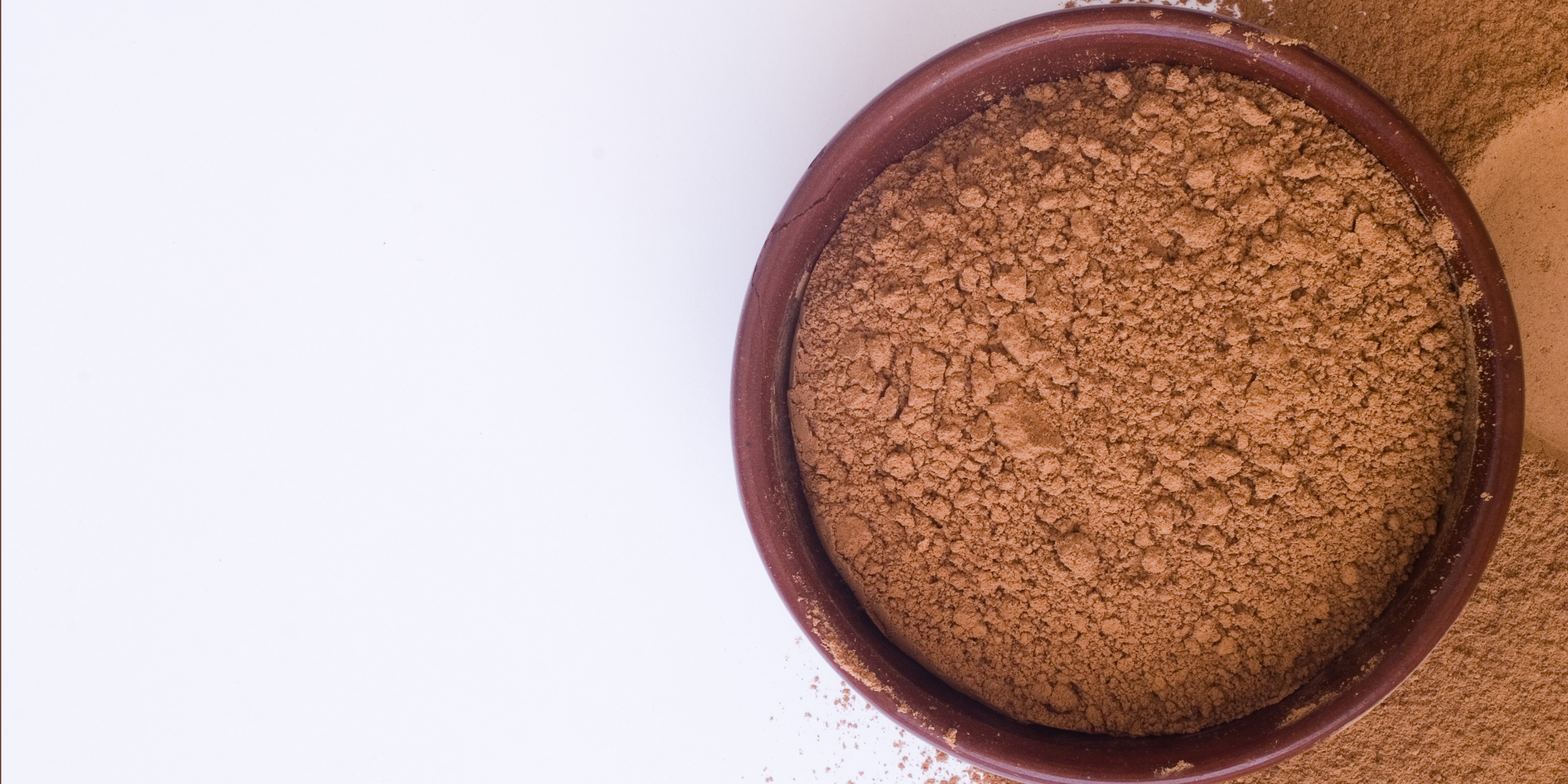 A brown bowl filled with cocoa powder