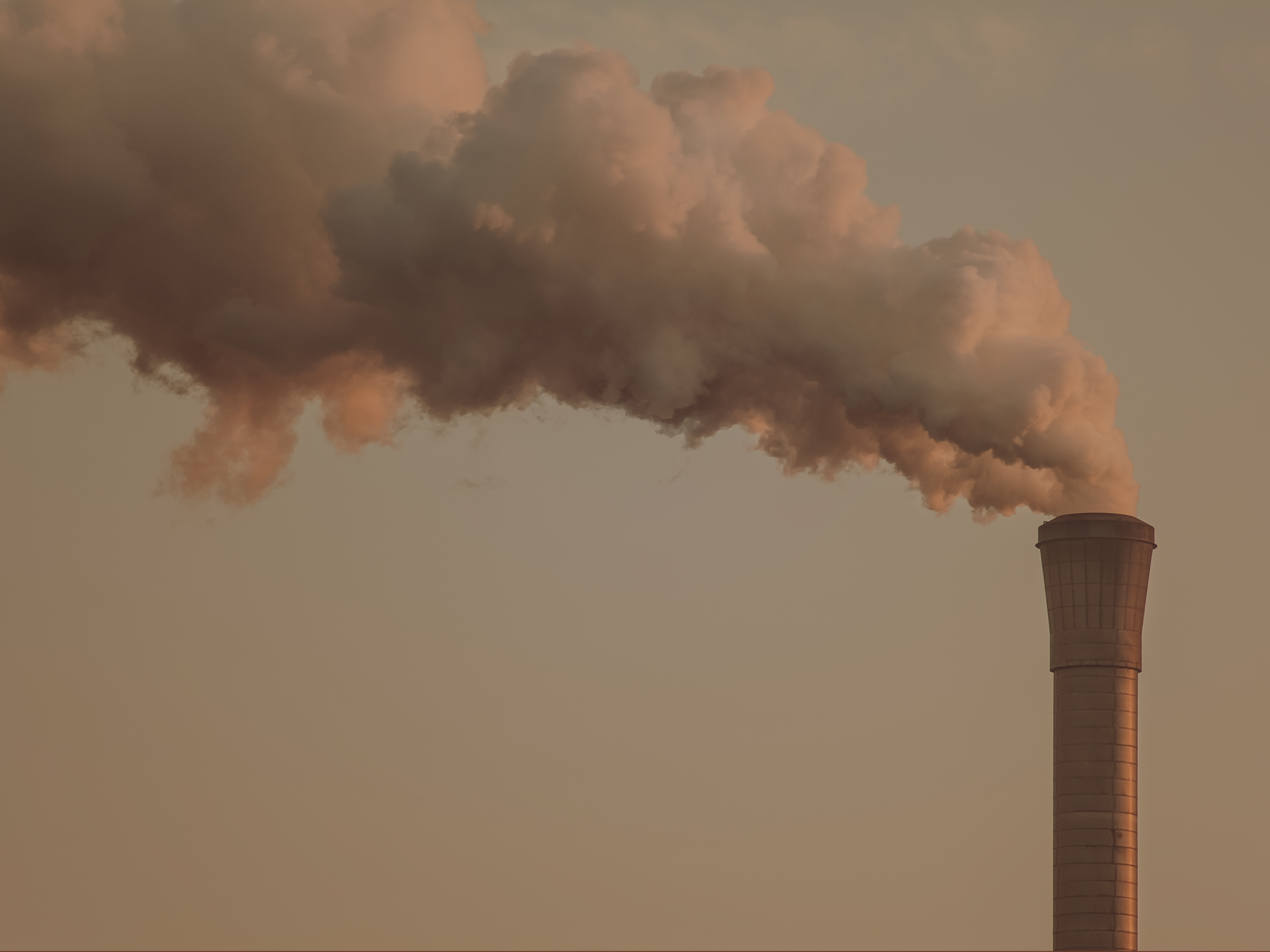 A factory pipe releasing fumes contributing to CO₂ emissions