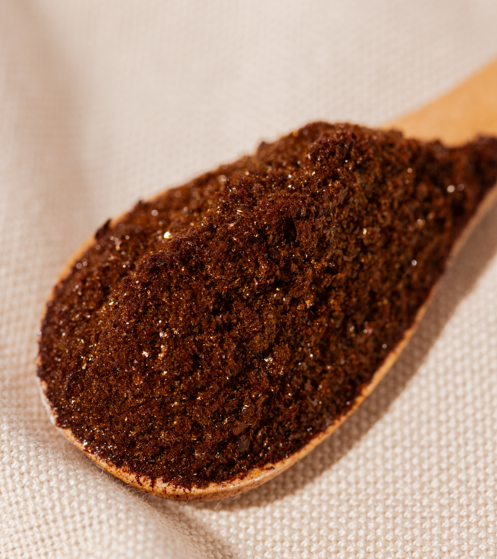 A wooden spoon holding Compound's black instant bean free coffee