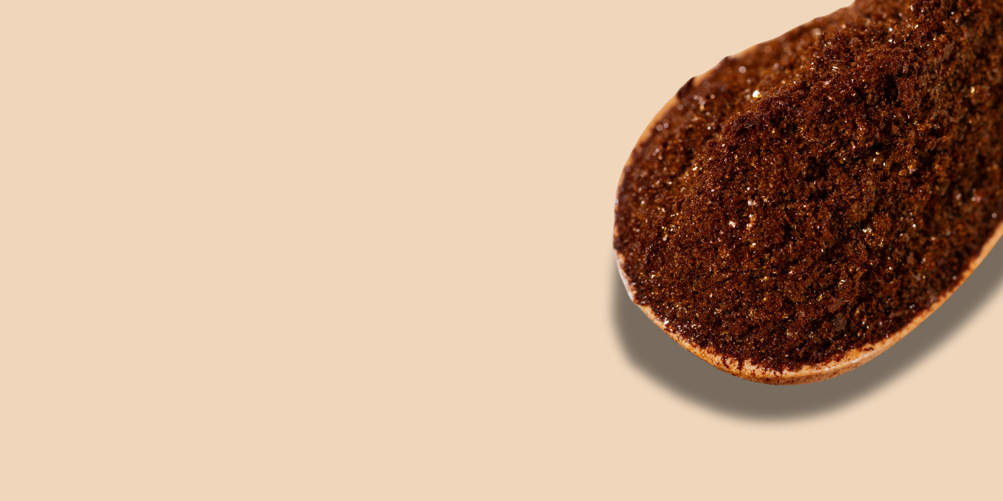 Compound's instant bean-free black coffee scooped in a wooden spoon