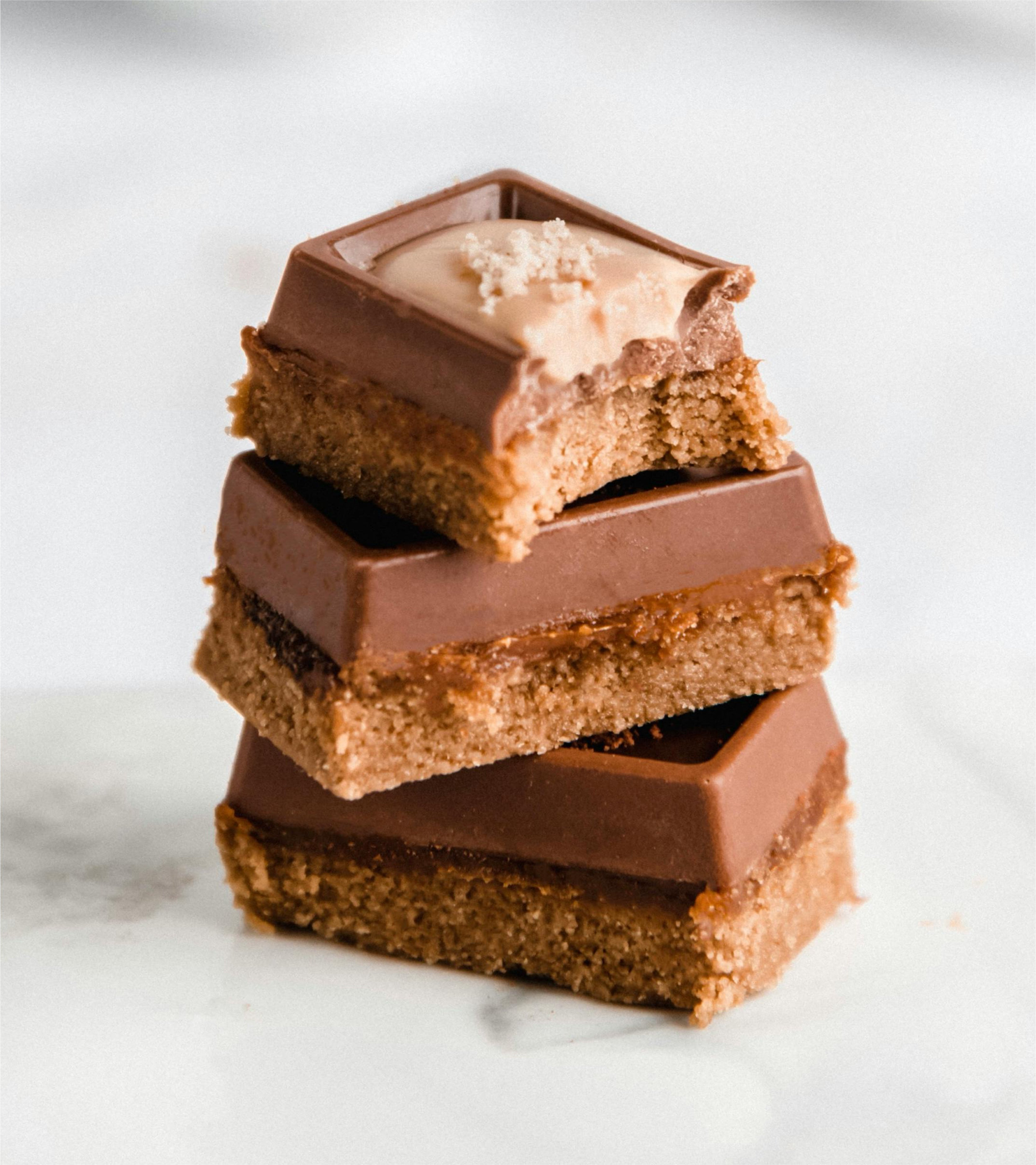 Three sea salt chocolate bars pilled up on top of each other on a white background